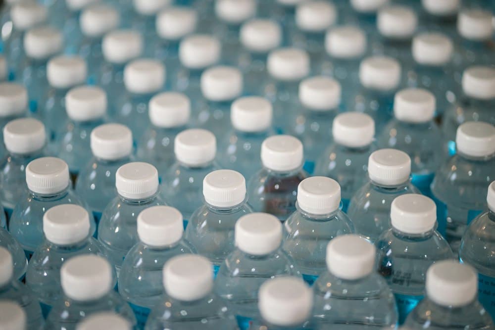 Rows of clear plastic water bottles with white caps